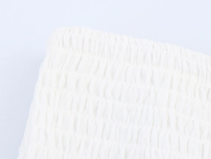 Close-up of white elastic shirred fabric detailing on the summer vacation dress