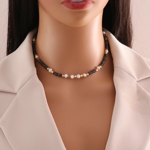 Elegant beaded necklace with natural stone, gold cubes and pearls on a model