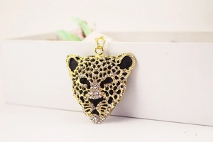 Close-up of golden leopard keychain with sparkling rhinestones on a white gift box