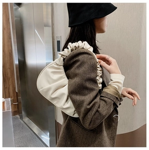 Elegante borsa hobo beige arricciata indossata da una modella in un outfit chic
