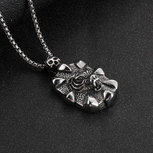 Macro shot of silver skull and claw rectangular pendant on a square box chain