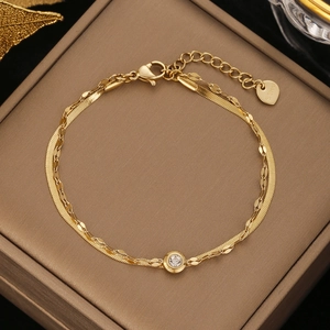 Detail of gold-plated double-layer stainless steel bracelet with a white zircon stone
