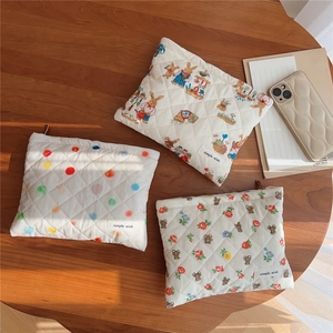 Detailed view of quilted cotton pouches featuring rabbit, polka dot, and teddy bear prints