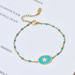 Detailed macro view of the gold-plated stainless steel star charm and turquoise beads