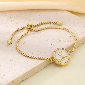 Close-up of golden box chain bracelet with sparkling crystal paved Mãe pendant