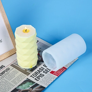 Macro shot of geometric diamond pillar candle with its silicone mold on blue background