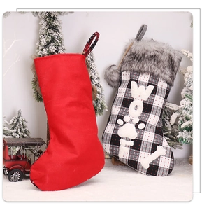 Detail of plaid Christmas stockings with faux fur trim and dog bone decorations in a snowy scene