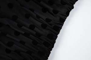 Detail of black polka dot mesh fabric featuring soft flocking and sheer texture details
