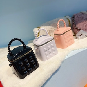 Detailed view of mini studded jelly bucket bags in black, purple and pink on faux fur