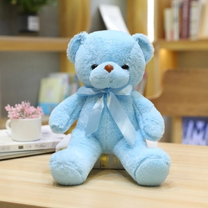 Adorable osito de peluche azul con lazo a juego sobre un acogedor escritorio de madera