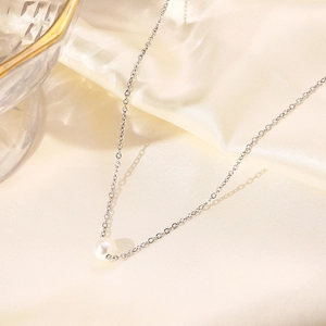 Detailed macro view of a 7-8mm lustrous white pearl pendant on a fine silver steel chain