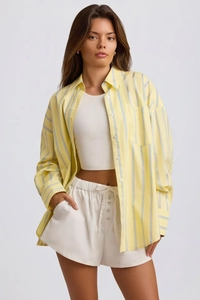 Detail of light yellow striped oversized shirt with casual drawstring shorts set