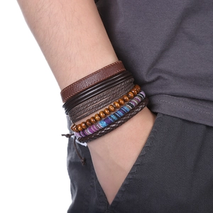 Détail de bracelets multicouches en cuir et perles en bois sur un poignet masculin