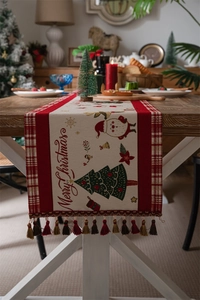 Detail of Christmas table runner with Merry Christmas embroidery and red plaid fringe