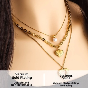 Detail view of triple-layered gold-plated chain necklace with pearls and heart pendants