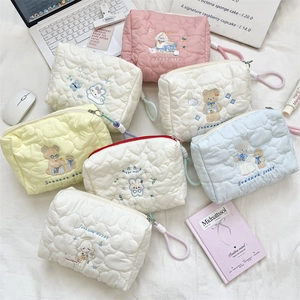 Detail of heart-quilted cosmetic bags with cute animal embroidery and zip closure