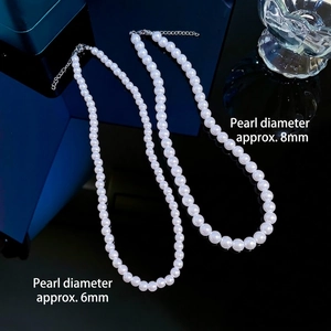6mm and 8mm round white pearl necklaces with adjustable silver clasps on dark mirror surface