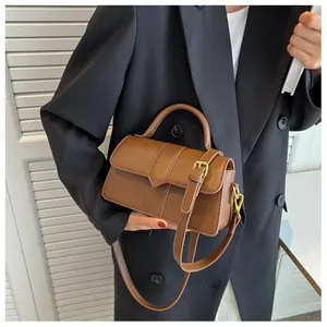 Détail du sac à main en cuir marron avec rabat en V et bandoulière réglable chic