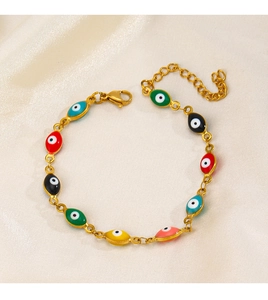 Détails des breloques œil de protection en émail coloré sur un bracelet doré en inox