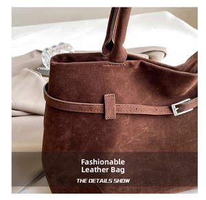Close-up of brown suede tote bag featuring adjustable side straps and silver hardware