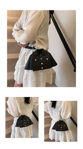 Detail of creative black jacket-shaped crossbody bag with metal chain and PU leather