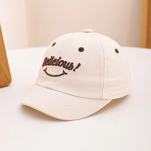 Close-up of cream cotton baby baseball cap with Delicious smile embroidery