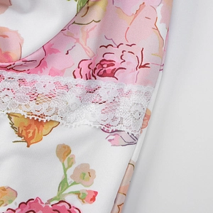 Gros plan sur le tissu à fleurs avec bordure en dentelle blanche sur la robe