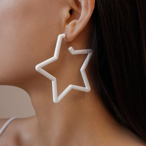 Gros plan d'un modèle portant de grandes boucles d'oreilles étoiles blanches en acrylique