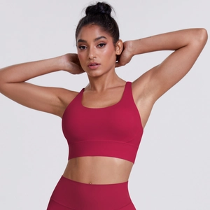 Detail view of the seamless high-stretch fabric on dark red sports bra and leggings