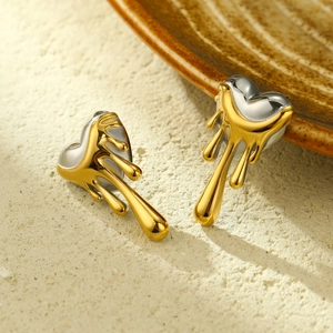 Modern molten gold dripping on silver heart stud earrings with luxury lava design