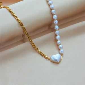 Golden Cuban chain necklace with white pearls and a pearl heart pendant on beige silk