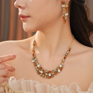 Macro shot of vintage style gold-toned necklace and earrings set with amber crystals