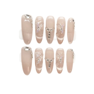 Long almond nude cat-eye press-on nails with 3D butterfly, rhinestones, and pearls