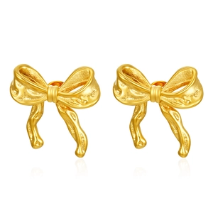Detailed view of gold plated bowknot stud earrings with textured metallic finish