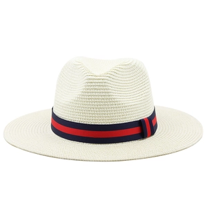 Klassischer cremefarbener Strohhut mit rot-blauem Streifenband für den Sommerurlaub