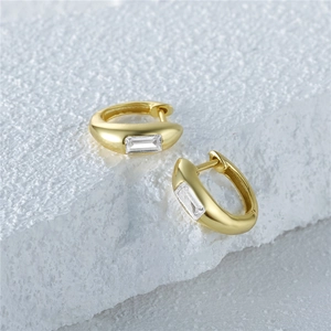 Close-up of S925 silver gold-plated square zircon hoop earring on white textured stone