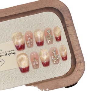 Red cat eye press-on nails with luxury gold snake charms and sparkling rhinestones