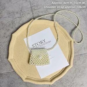 Mini handmade pearl woven crossbody bag with large pearl clasp on elegant display