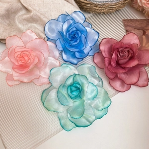 Detailed view of handmade fabric flower hair clips in pink, blue, burgundy, and green tones