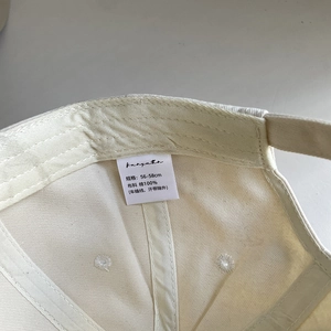 Detail of the internal cotton lining and size label for the white embroidery baseball cap