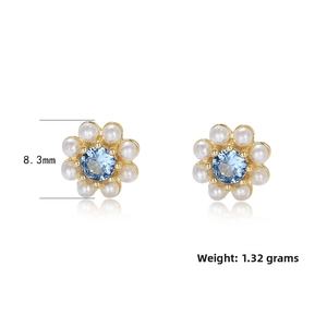 Detailed view of flower stud earrings featuring blue zircon and pearls with 8.3mm diameter