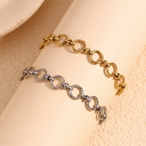 Detail of interlocking round link chains in gold and silver finish on a woman's wrist