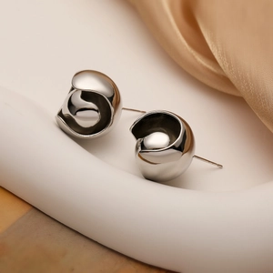 Pendientes de botón esféricos geométricos plateados sobre un fondo elegante
