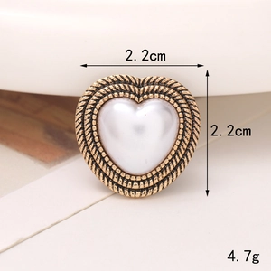 Vista macro di charm per scarpe a cuore con perla, bordo dorato e misure di 2,2 cm