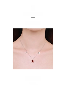 Detail of S925 silver necklace with rectangular ruby pendant and delicate charms