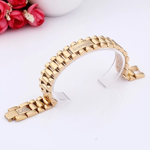 Detail of gold titanium steel watch-style bracelet featuring a secure fold-over clasp