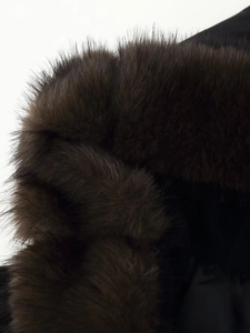 Close-up of the fluffy dark brown faux fur collar detail on a hooded wool coat