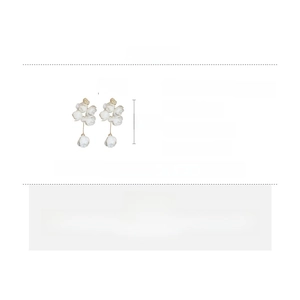 Detailed specs of long floral tassel earrings with white fabric flowers and pearls
