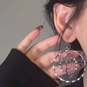 Chic layered silver circular hoop earrings with hammered texture on minimalist model