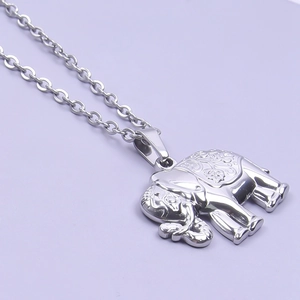 Detail of silver elephant pendant with intricate carvings on a minimalist metal chain